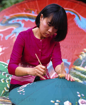 Kvinna tillverkar parasoll, Thailand