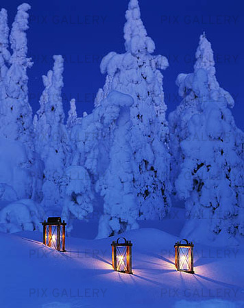 Tre ljuslyktor i snö