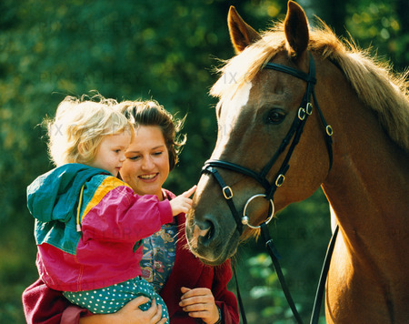 Kvinna och barn vid häst