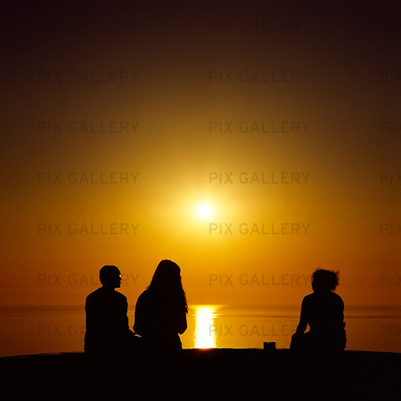 Människor i solnedgång vid havet