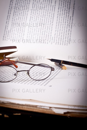 Gammal bok med en penna och gamla glasögon