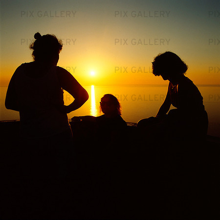 Kvinnor i solnedgång vid havet