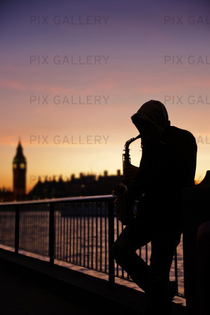 Saxophone player on the South Bank at dusk with Big Ben in the background, London, Greater London, England, UK, Europe