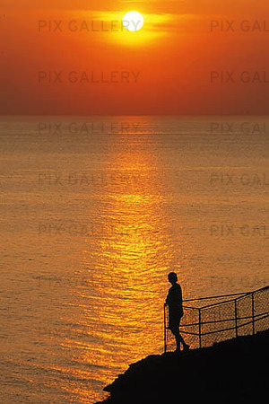 Man in the sunset at sea