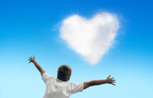 Pojke med hjärtformat moln på himlen