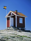 Röd stuga med Svensk flagga