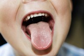 Barn som räcker ut tungan