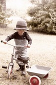 Liten pojke med trehjuling
