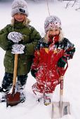 Två flickor med snöspadar