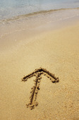 Arrow sign drawn in sand