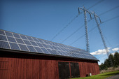 Kraftledning vid ladugård med solpaneler på taket