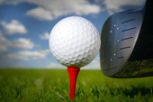 Golfklubba och boll i gräset