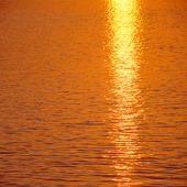 Solnedgång speglas i vattenyta