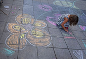 Flicka som ritar på gatan