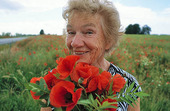 Mature woman with poppy flowers