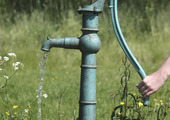 Old-fashioned water pump in sunny meadow